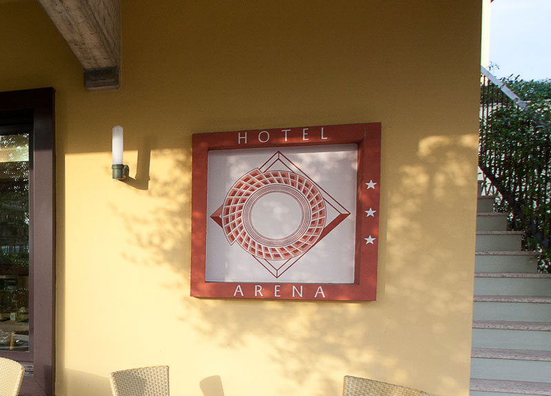 Logo dell’hotel Arena ispirato all’Arena di Verona, con arena stilizzata vista dall’alto